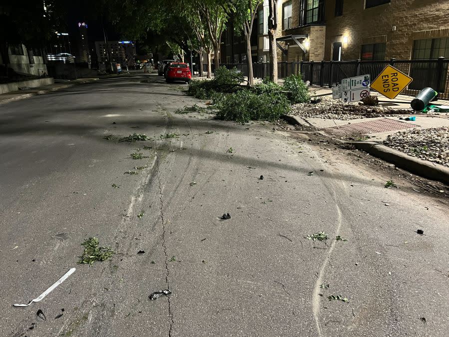 Damage to cars, street signs, etc. along East 9th Street near Embassy Drive after an 18-wheeler crashed into 10 parked vehicles overnight April 22, 2024 (KXAN Photo/Todd Bailey)