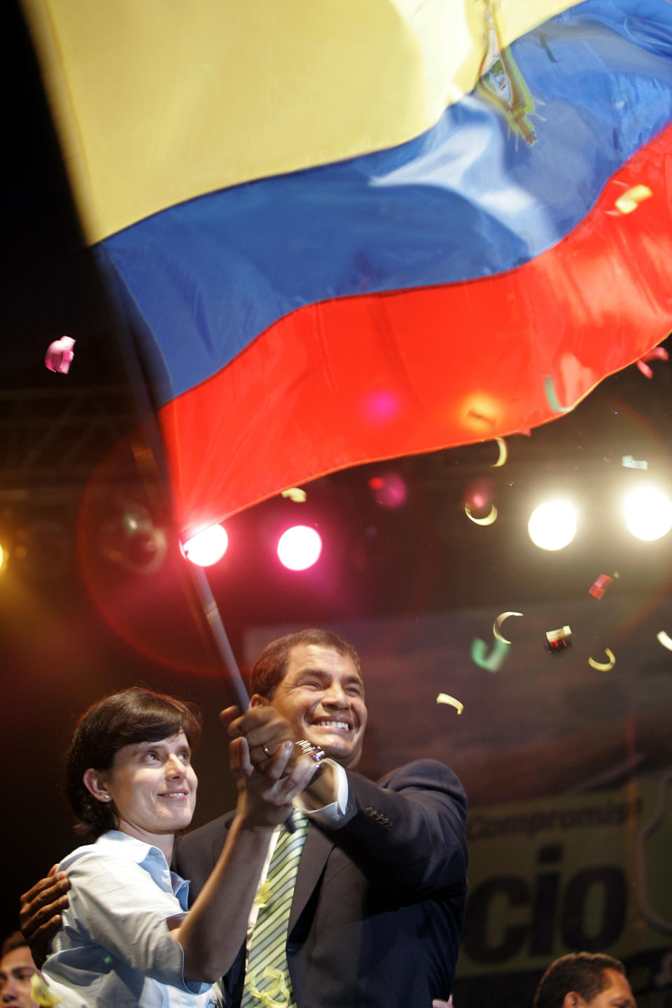 FILE - In this Nov. 26, 2006 file photo, newly-elected President Rafael Correa and his wife Anne Malherbe hold a national flag during a victory celebration, in Quito, Ecuador. Love him or hate him, most Ecuadoreans credit Correa with delivering stability after a tumultuous period that saw a musical chairs of eight presidents in a decade and an economic and banking collapse that forced Ecuador to abandon its own currency and adopt the U.S. dollar. But he did so with an iron hand that has silenced or punished critics among the press, opposition and judiciary. (AP Photo/Martin Mejia, File)