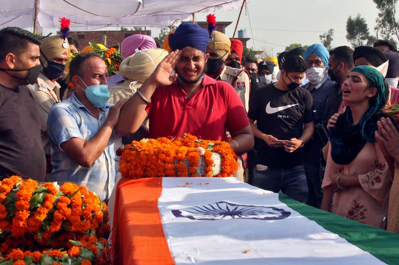 FILE PHOTO: Prabhjot Singh, son of Satnam Singh, an Indian soldier who was killed in a border clash with Chinese troops in Ladakh region, reacts next to the coffin of his father during his funeral ceremony in Bhojraj