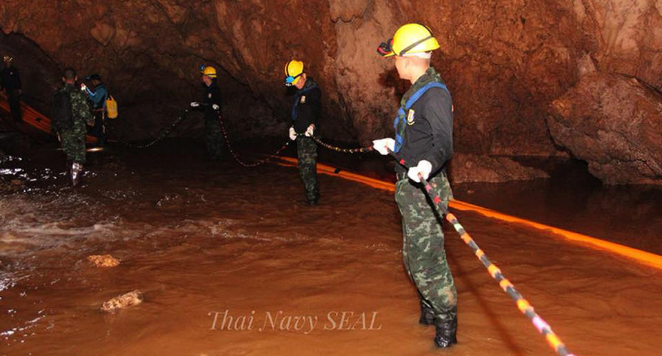 Thai military personnel carrying equipment inside a cave complex during the ongoing rescue operations. Source: EPA via AAP