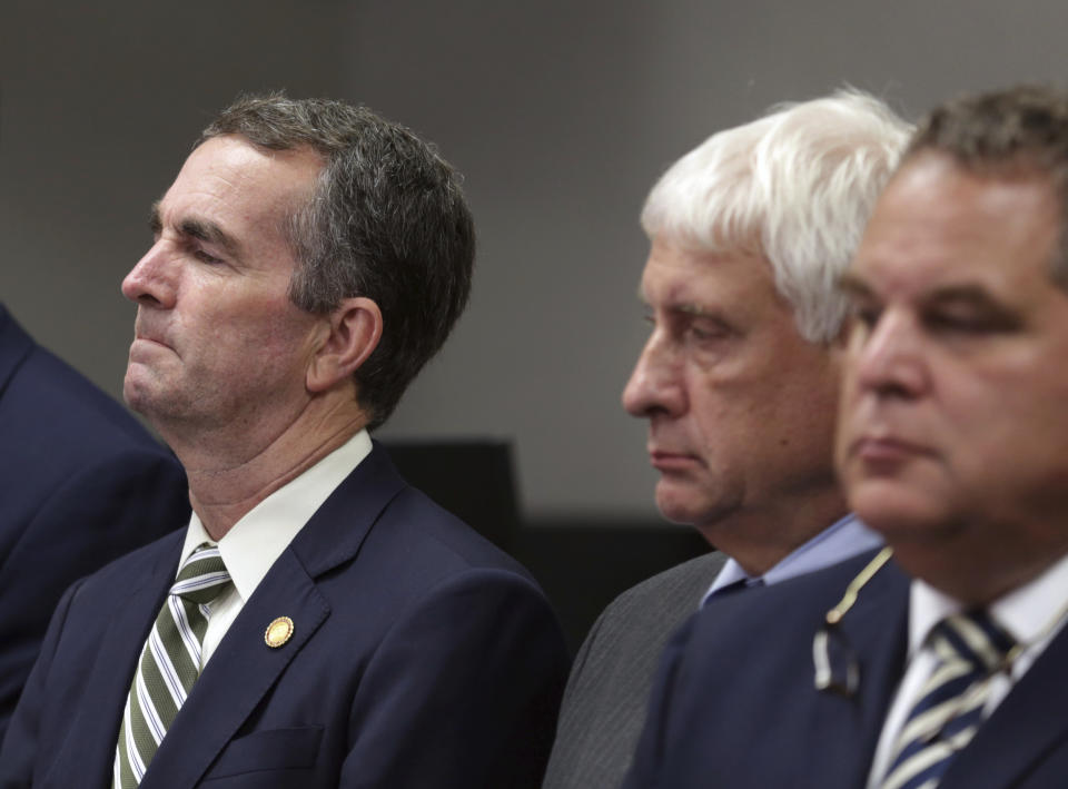 Virginia Gov/ Ralph Northam, left, listens during a news conference in Virginia Beach, Va. Friday, May 31, 2019. A longtime city employee opened fire in a municipal building in Virginia Beach on Friday, killing several people on three floors and sending terrified co-workers scrambling for cover before police shot and killed him following a "long gun-battle," authorities said. (AP Photo/Vicki Cronis-Nohe)