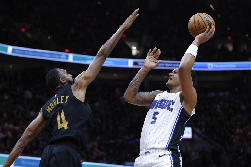 Orlando Magic forward Paolo Banchero (5) shoots against Cleveland Cavaliers forward Evan Mobley (4) during the second half of Game 5 of an NBA basketball first-round playoff series, Tuesday, April 30, 2024, in Cleveland. (AP Photo/Ron Schwane)