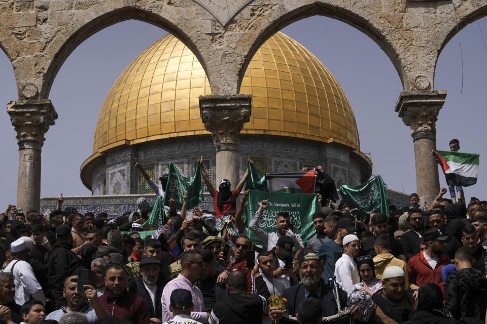 Palestinians hold the Palestinian national flag and the flag of the Hamas militant group during a protest by the Dome of Rock at the Al-Aqsa Mosque compound in the Old City of Jerusalem during the Muslim holy month of Ramadan, Friday, April 7, 2023. The Israeli military has struck targets in the Gaza Strip, pushing the region toward a wider conflagration after a day of rocket fire along the country's northern border with Lebanon and southern borders with the Gaza Strip. The fighting follows two days of unrest at Jerusalem's most sensitive holy site. (AP Photo/Mahmoud Illean)