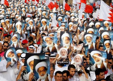 Anti-government protesters hold posters of Shi'ite cleric Ayatollah Sheikh Isa Qassim during an anti-government protest organised by Bahrain's main opposition group Al Wefaq, in Budaiya, west of Manama, Bahrain May 17, 2013. REUTERS/Hamad I Mohammed/File Photo