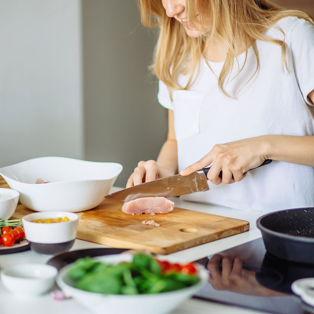 Woman preparing chicken for cooking