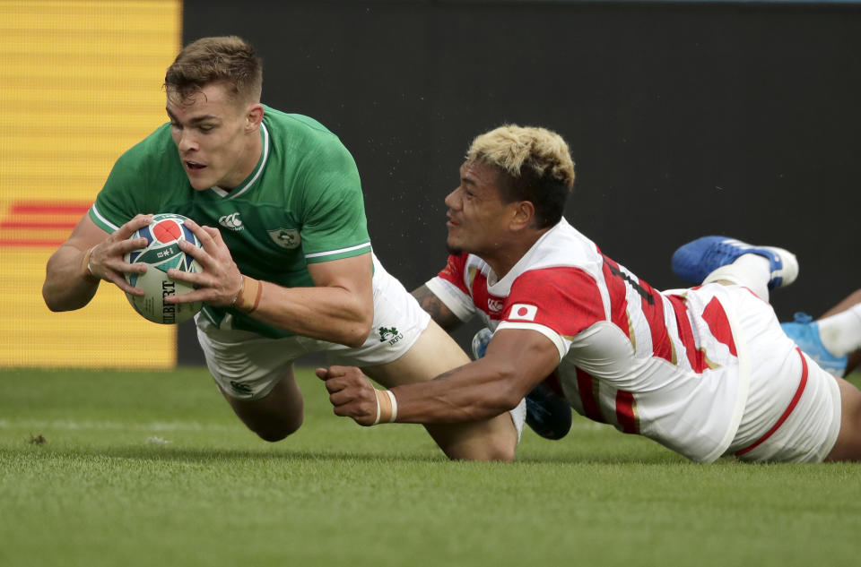 Ireland's Garry Ringrose, right, scores a try as he is tackled by Japan's Lomano Lava Lemeki during the Rugby World Cup Pool A game at Shizuoka Stadium Ecopa between Japan and Ireland in Shizuoka, Japan, Saturday, Sept. 28, 2019. (AP Photo/Jae Hong)