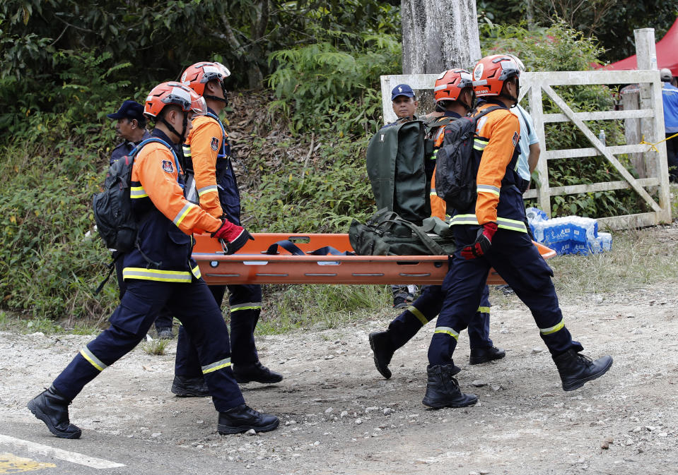 Rescue team prepare equipment near the site of a landslide at an organic farm in Batang Kali, Malaysia, Friday, Dec. 16, 2022. Dozens of Malaysians were believed to have been at a tourist campground in Batang Kali, outside the capital of Kuala Lumpur, when the incident occurred, said a district police chief. (AP Photo/FL Wong)