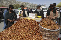 FILE - In this Wednesday, April 7, 2021, file photo, a street vendor sells dates ahead of the upcoming Muslim fasting month of Ramadan, in Kabul, Afghanistan. Muslims are facing their second Ramadan in the shadow of the pandemic. Many Muslim majority countries have been hit by an intense new coronavirus wave. While some countries imposed new Ramadan restrictions, concern is high that the month’s rituals could stoke a further surge. (AP Photo/Rahmat Gul, File)