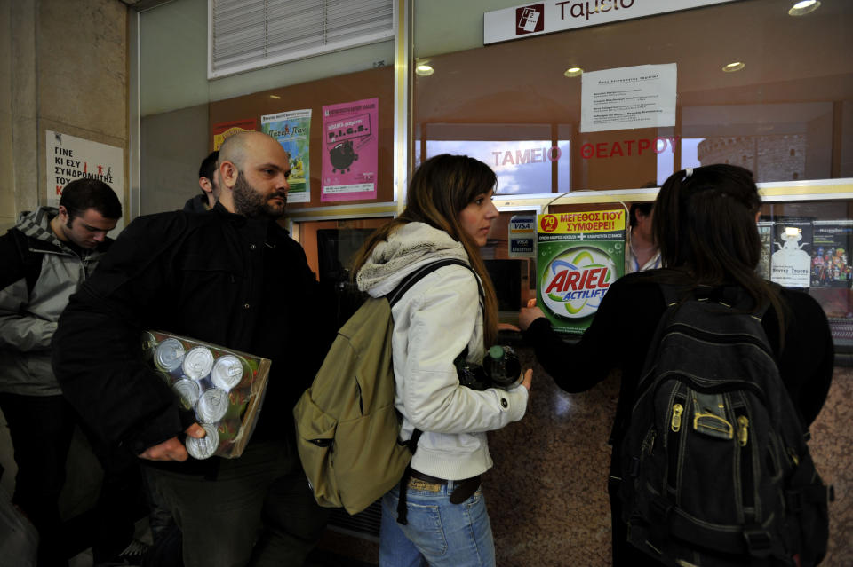 Greeks hold food as they wait at a box office of a theater in the northern port city of Thessaloniki, Greece, on Friday, March 30, 2012. Amid the country's acute financial crisis, the State Theater of Northern Greece has launched a series of performances where, instead of cash, spectators can hand over food at the ticket booth.(AP Photo/Nikolas Giakoumidis)