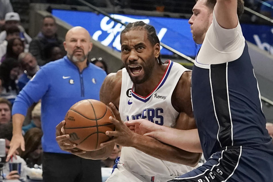 Los Angeles Clippers forward Kawhi Leonard drives against Dallas Mavericks guard Luka Doncic as head coach Jason Kidd looks one during the first half of an NBA basketball game in Dallas, Sunday, Jan. 22, 2023. (AP Photo/LM Otero)