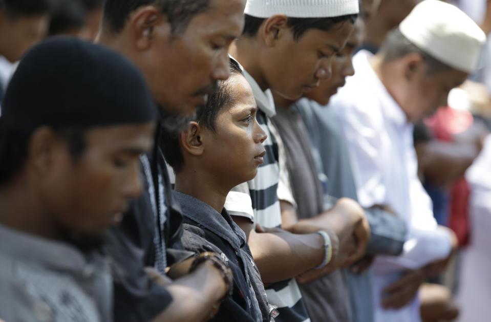 A boy is teary-eyed as he joins during Friday prayers outside a damaged mosque caused by the massive earthquake and tsunami in Palu, Central Sulawesi, Indonesia Oct. 5, 2018. French rescuers say they've been unable to find the possible sign of life they detected a day earlier under the rubble of a hotel that collapsed in the earthquake a week ago on Indonesia's Sulawesi island. (AP Photo/Aaron Favila)