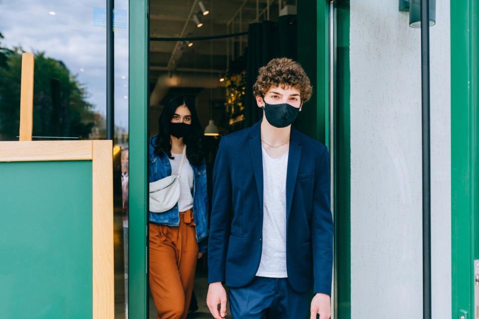People in masks leaving a cafe together