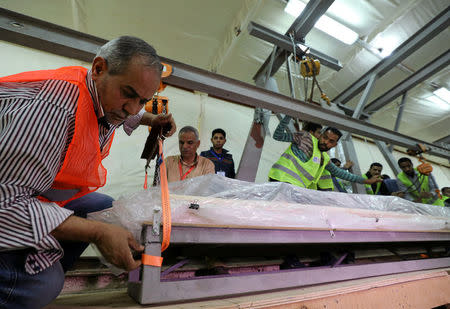 A team prepares a wooden piece of the second Khufu boat in order to transfer it to a lab where it will be restored, in Giza, Egypt March 29, 2017. REUTERS/Mohamed Abd El Ghany