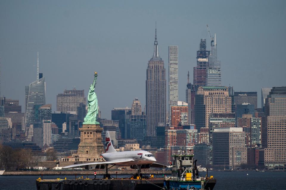 A retired British-Airways Concorde supersonic airliner is moved on a barge up the Hudson River on March 13, 2024 seen from Bayonne, New Jersey with the Statue of Liberty and New York skyline in the background.