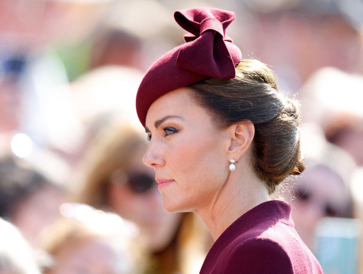 Kate Middleton wearing a deep-red fascinator.