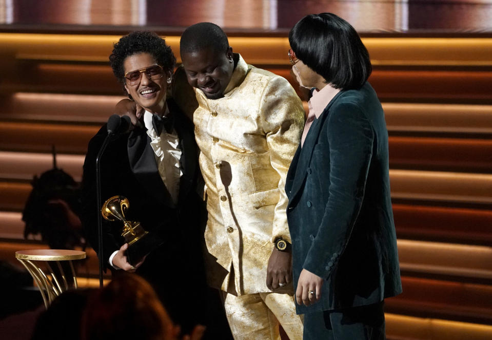 Dernst Emile II, en el centro, Bruno Mars, a la izquierda, y Anderson .Paak, de Silk Sonic, reciben el Grammy a la canción del año por "Leave the Door Open" el domingo 3 de abril de 2022 en Las Vegas. (Foto AP/Chris Pizzello)