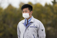 Yuya Hatakeyama, a Tomioka town official, speaks during an interview with The Associated Press as he guides reporters in a "difficult-to-return" zone in Tomioka town, Fukushima prefecture, northeastern Japan, Friday, Feb. 26, 2021. Hatakeyama, forced to evacuate as a 14-year-old junior high school student, is back in town as a rookie official. Now at age 24, Hatakeyama wants to help rebuild the community and reconnect residents for the struggling town. (AP Photo/Hiro Komae)