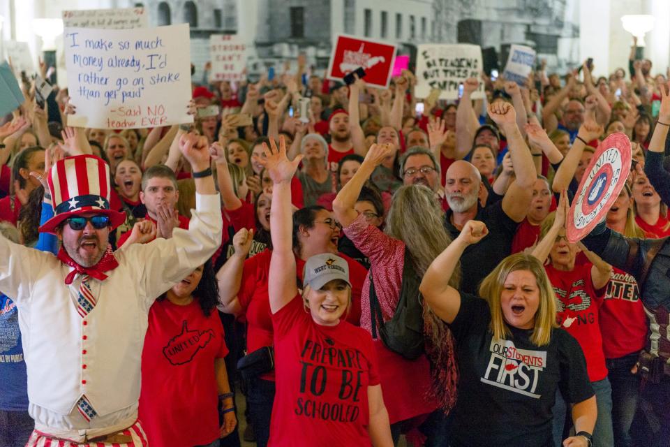 School staff celebrate after the House of Delegates passed a motion to postpone a vote on Senate Bill 451 indefinitely at the West Virginia State Capitol in Charleston, W.Va., during a statewide teachers' strike on Tuesday, Feb. 19, 2019.