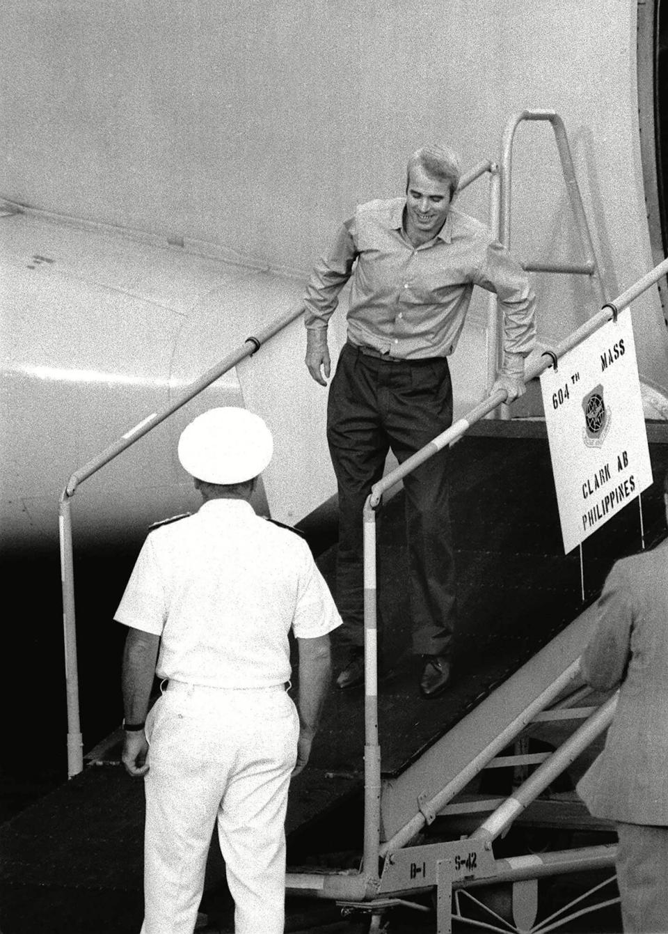Lt. Cdr. John McCain limps down ramp for a welcome as he arrives at Clark Air Base in The Philippines, from captivity in Hanoi.