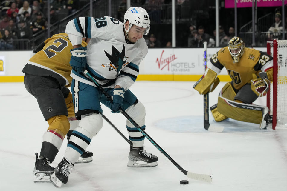 San Jose Sharks right wing Timo Meier (28) attempts to skate around Vegas Golden Knights defenseman Zach Whitecloud (2) during the first period of an NHL hockey game Thursday, Feb. 16, 2023, in Las Vegas. (AP Photo/John Locher)