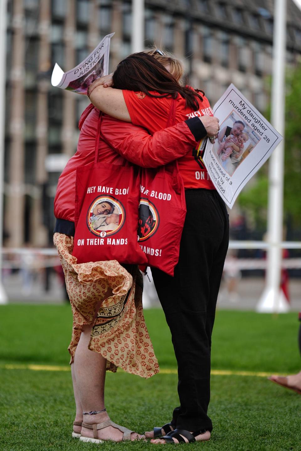 Infected blood campaigners hug in London (Aaron Chown/PA Wire)