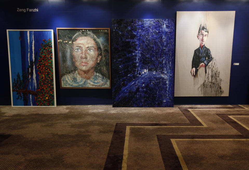Two paintings titled "Portrait", second from left, and "Trauma", right, by Chinese artist Zeng Fanzhi are displayed for sale at the Seoul Auction in Hong Kong Tuesday, April 3, 2012. Auctioneers in Hong Kong have sold 10 paintings seized from a South Korean bank that collapsed last year amid a corruption scandal to raise $2.4 million to help repay depositors. The paintings included works by noted Chinese artists Zeng and Zhang Xiaogang and American Julian Schnabel. (AP Photo/Kin Cheung)