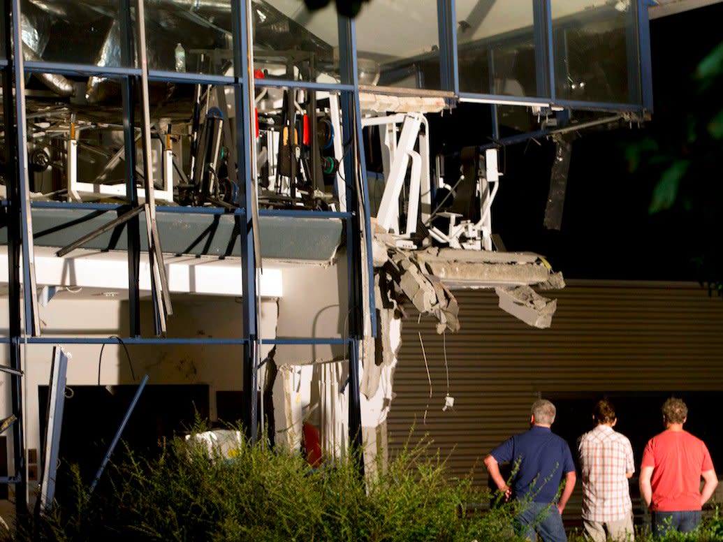 Police inspectors survey the scene of a blast at a sports complex in Chimay, Belgium, Friday, Aug. 26, 2016.