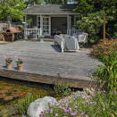 <p> Dark weathered decking can to the rustic appeal of a garden. Choose a material that will weather well and surrounding the raised decking with perennials. If you have the space, consider building in a shallow pond or other water features below the decking for a truly striking garden. </p>