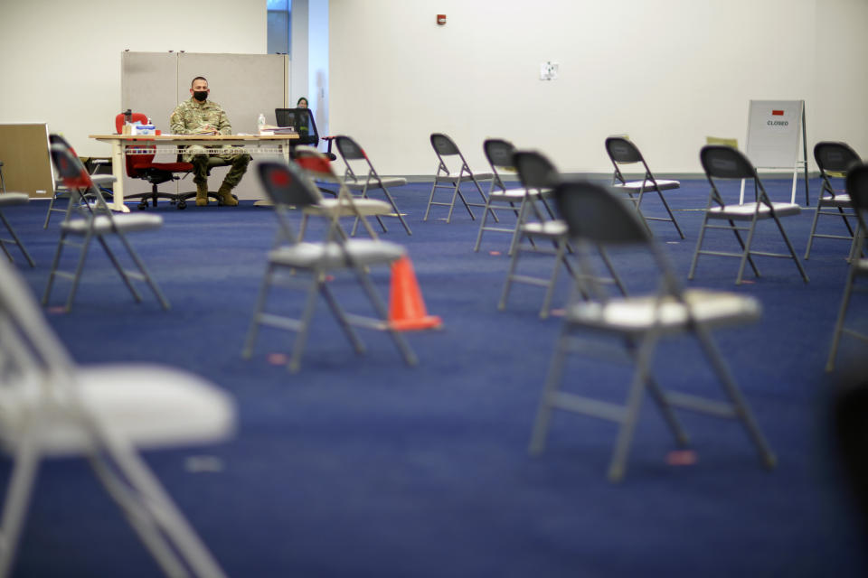 Rhode Island Army National Guard Sgt. Juan Gomez looks over the post inoculation waiting area at a coronavirus mass-vaccination site at the former Citizens Bank headquarters in Cranston, R.I., Thursday, June 10, 2021. The U.S. is confronted with an ever-growing surplus of COVID-19 vaccines, looming expiration dates and stubbornly lagging demand at a time when the developing world is clamoring for doses to stem a rise in infections. (AP Photo/David Goldman)