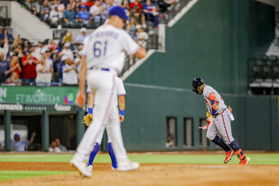 Atlanta Braves batter Ronald Acuña Jr., right, celebrates after hitting a home run while Texas Rangers pitcher Cody Bradford, left, looks on in the top of the second inning of a baseball game in Arlington, Texas, Monday, May 15, 2023. (AP Photo/Gareth Patterson)