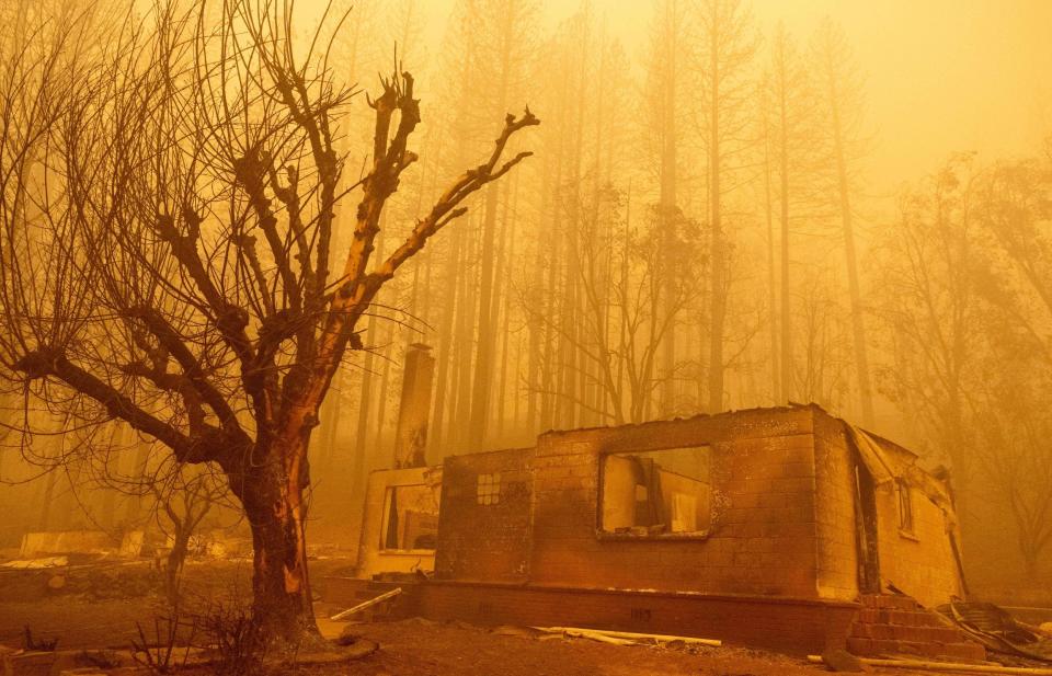 A burned residence rest in heavy smoke during the Dixie fire in Greenville, California on Aug. 6, 2021.