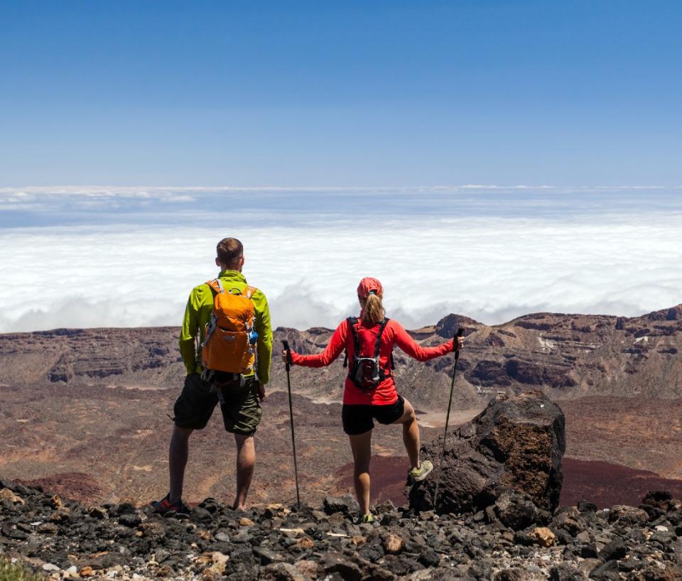 Hiking couple standing on a mountain top above the clouds on Tenerife.