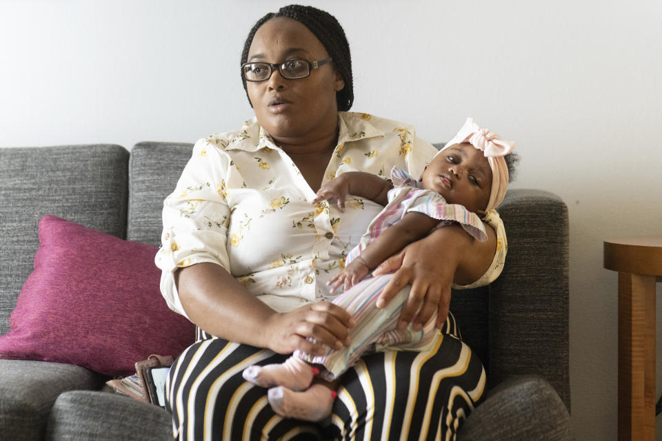 Asian Davis, 33, of Sikeston, Mo., cradles her 8-month-old daughter Mira White, during an interview on Oct. 3, 2023, in St. Louis. Davis and her lawyers say Mira suffered brain damage in March after developing bacterial meningitis tied to powdered infant formula contaminated with Cronobacter sakazakii, a germ known to cause severe disease in young babies. (AP Photo/Michael Thomas)