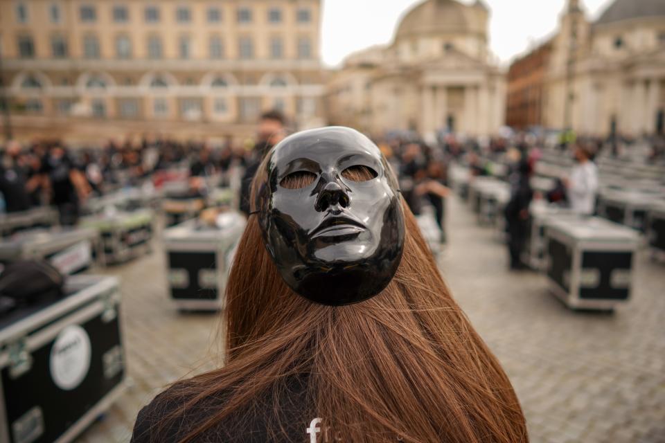 Entertainment workers gather in Piazza del Popolo Square to protest against the Italian government's economic policies to combat the spread of COVID-19 and to demand to reopen their business, in Rome, Saturday, April 17, 2021. (AP Photo/Andrew Medichini)