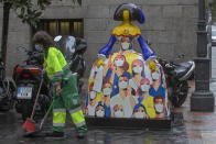 Una empleada municipal de limpieza barre cerca de una de las "Meninas", decorada con figuras de médicos en agradecimiento por su labor, en Madrid, el 22 de octubre de 2020. España se convirtió esta semana en el primer país de Europa en registrar más de 1 millón de casos de coronavirus. (AP Photo/Paul White)