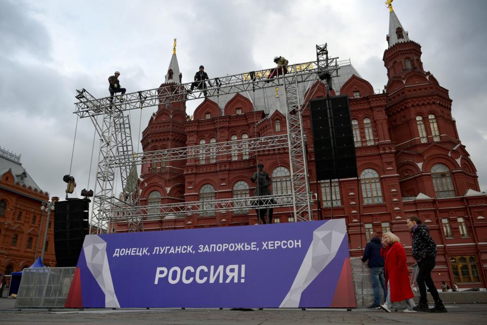 Workers fix a banner reading “Donetsk, Lugansk, Zaporizhzhia, Kherson - Russia!” on top of a construction installed in front of the State Historical Museum outside Red Square in central Moscow (AFP via Getty Images)