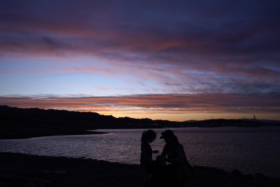 FILE - A mother and child stop along the shoreline of Lake Mead at the Lake Mead National Recreation Area, May 10, 2022, near Boulder City, Nev. Community leaders along the Mississippi River worried that dry southwestern states will someday try to take the river's water may soon take their first step toward blocking such a diversion. (AP Photo/John Locher, File)