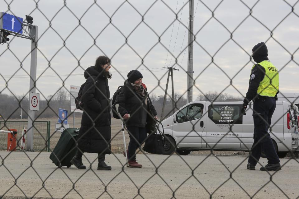 Police officers directs refugees fleeing conflict in Ukraine as they arrive, at the Medyka border crossing, in Poland, Sunday, Feb. 27, 2022. Since Russia launched its offensive on Ukraine, more than 200,000 people have been forced to flee the country to bordering nations like Romania, Poland, Hungary, Moldova, and the Czech Republic — in what the U.N. refugee agency, UNHCR, said will have "devastating humanitarian consequences" on civilians. (AP Photo/Visar Kryeziu)