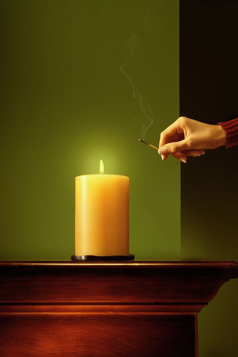 A woman lighting a candle with a match
