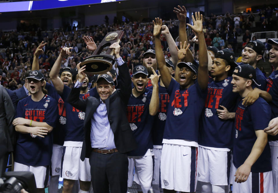 Gonzaga head coach Mark Few, center, holds a trophy with his team after beating Xavier during an NCAA Tournament college basketball regional final game Saturday, March 25, 2017, in San Jose, Calif. (AP Photo/Tony Avelar)