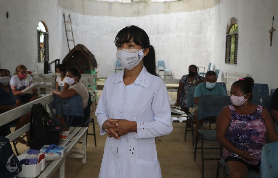 Health worker Vanda Ortega from the Witoto Indigenous group stands during a COVID-19 testing drive at the Indigenous Park, a tribal community in the outskirts of Manaus, Amazonas state, Brazil, Thursday, Jan. 7, 2021. Medical teams are scrambling to assist indigenous people living in outlying areas of Manaus, where medical care is scarce after authorities issued a "State of Emergency" due to rising numbers of infection numbers in Amazonas State. (AP Photo/Edmar Barros)