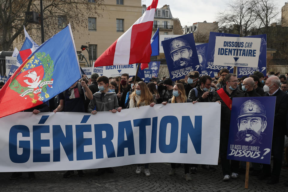 FILE - In this Feb.20, 2021 file photo, supporters of the group Generation Identity hold a banner reading "Man does not dissolve a generation" during a demonstration in Paris. French Interior Minister Gerald Darmanin announced Wednesday the dissolution of the anti-migrant group Generation Identity during a Cabinet meeting on the ground it is encouraging discrimination in the country. (AP Photo/Francois Mori, File)