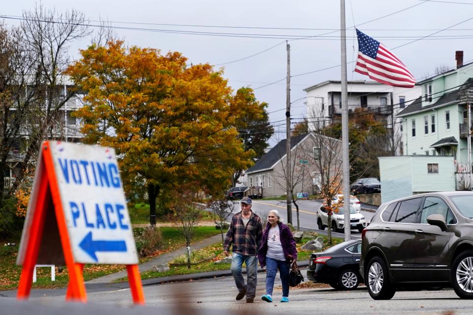 Voters arrive at a polling place at the Gov. James B. Longley Campus, Tuesday, Nov. 7, 2023, in Lewiston, Maine. The American flag still flies at half-mast in honor of the 18 people who were killed in mass shootings less than two weeks ago.