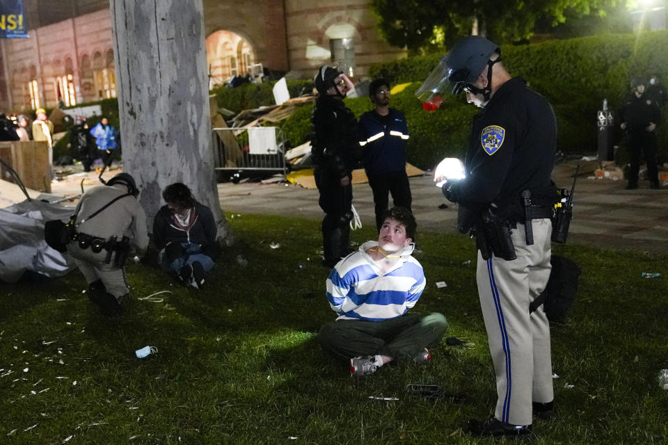 FILE - Demonstrators are detained by police in an encampment set up by pro-Palestinian demonstrators on the UCLA campus Thursday, May 2, 2024, in Los Angeles. (AP Photo/Jae C. Hong, File)