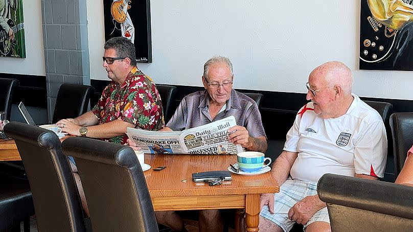 Ciudadanos británicos residentes en España leen la prensa inglesa en un bar de Rojales, Alicante