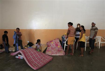 A family gathers at a school being used as a shelter for residents evacuated from the surrounding areas of the Chaparrastique volcano in the municipality of San Miguel December 30, 2013. REUTERS/Ulises Rodriguez