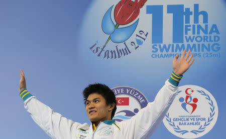 Silver medallist Kenneth To of Australia waves during the award ceremony for the men's 100m individual medley final during the FINA World Swimming Championships in Istanbul December 16, 2012. REUTERS/Murad Sezer