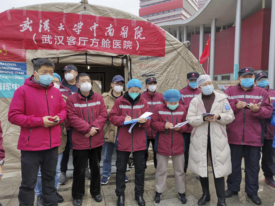 In this Feb. 14, 2020, photo released by Zhang Junjian, medical workers attend a morning conference outside a tent on the square in front of the Wuhan Living Room Temporary hospital in Wuhan in central China's Hubei province. The hospital is the largest of 16 temporary hospitals set up in gyms and other locations to handle an overflow of patients and try to stem the spread of the coronavirus by separating them from the rest of the city's 11-million inhabitants. (Zhang Junjian via AP)