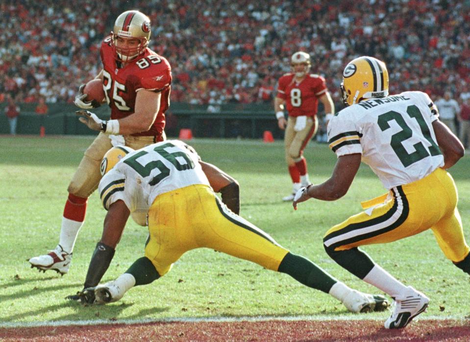 San Francisco 49ers tight end Greg Clark (85) runs around Green Bay Packers Lamont Hollinhquest (56) and Craig Newsome (21) to score his team&#39;s second touchdown after catching a pass from quarterback Steve Young (8) during third quarter action in their NFL playoff game January 3.

GMH/KM