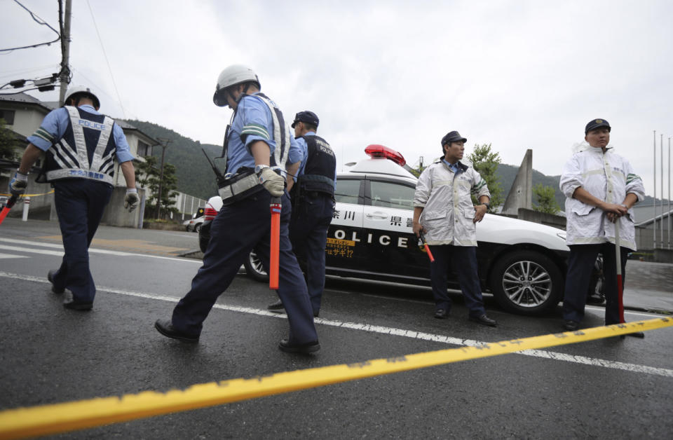 <p>Police officers stand guard at the main gate of Tsukui Yamayuri-en, a facility for the disabled where a number of people were killed and dozens injured in a knife attack in Sagamihara, outside Tokyo Tuesday, July 26, 2016. (AP Photo/Eugene Hoshiko)</p>